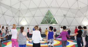Participants holding hands around the mandala
