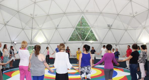 Participants holding hands around the mandala