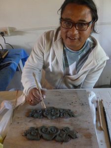 Migmar working on clay to make a mould